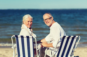 Image showing senior couple sitting on chairs at summer beach