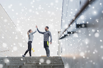 Image showing couple of sportsmen making high five outdoors