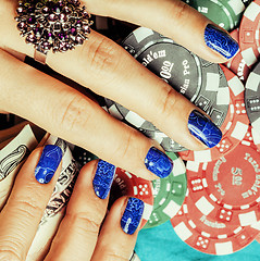 Image showing hands of young caucasian woman with blue manicure at casino tabl