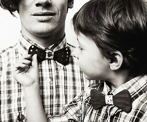 Image showing father with son in bowties on white background, casual look fami