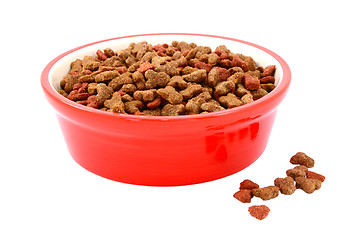 Image showing Dry cat food in a red bowl, biscuits spilled beside