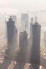 Image showing Skyscrappers construction site with cranes on top of buildings.