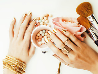 Image showing woman hands with golden manicure and many rings holding brushes,