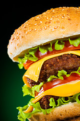 Image showing Tasty and appetizing hamburger on a darkly green