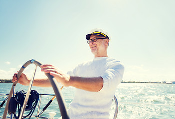 Image showing senior man at helm on boat or yacht sailing in sea