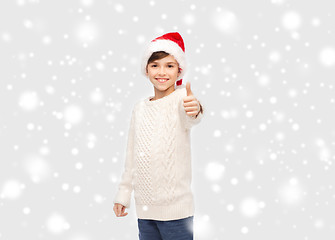 Image showing smiling happy boy in santa hat showing thumbs up