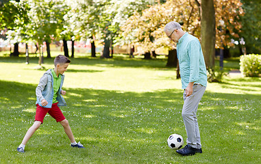 Image showing old man and boy playing football at summer park