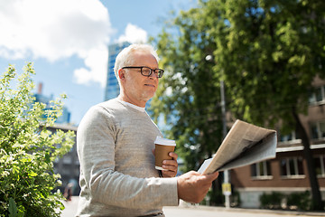 Image showing senior man reading newspaper and drinking coffee