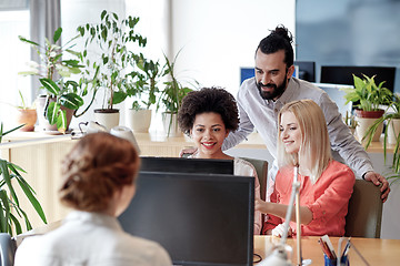 Image showing happy creative team with computer in office