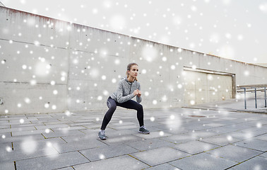 Image showing woman doing squats and exercising outdoors