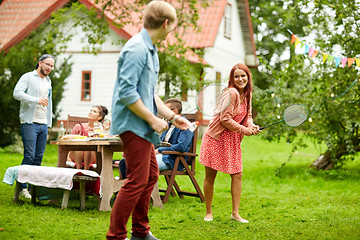 Image showing happy friends playing badminton at summer garden