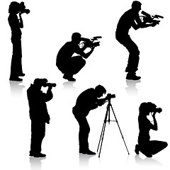 Image showing Set cameraman with video camera. Silhouettes on white background. illustration