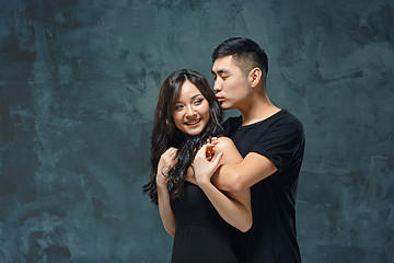 Image showing Portrait of smiling Korean couple on a gray