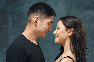 Image showing Portrait of smiling Korean couple on a gray