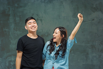 Image showing Portrait of smiling Korean couple on a gray