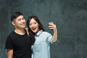 Image showing Portrait of smiling Korean couple on a gray