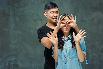 Image showing Portrait of smiling Korean couple on a gray