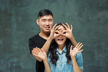 Image showing Portrait of smiling Korean couple on a gray