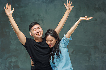 Image showing Portrait of smiling Korean couple on a gray