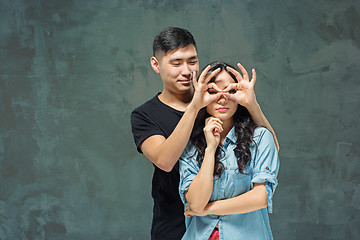 Image showing Portrait of smiling Korean couple on a gray