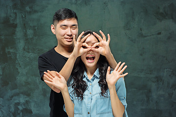 Image showing Portrait of smiling Korean couple on a gray