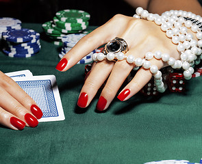 Image showing hands of young caucasian woman with red manicure at casino table