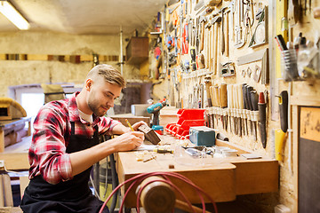 Image showing carpenter working with wood plank at workshop