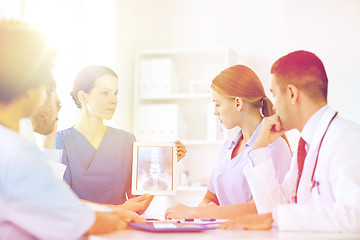 Image showing group of doctors with x-ray on tablet pc at clinic