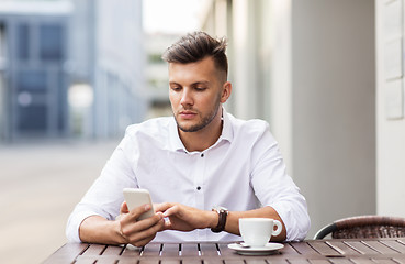 Image showing man with smartphone and coffee at city cafe