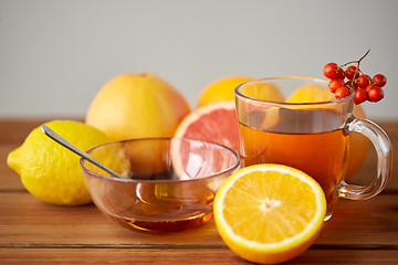 Image showing tea with honey, lemon and rowanberry on wood