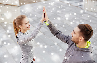 Image showing couple of sportsmen making high five outdoors