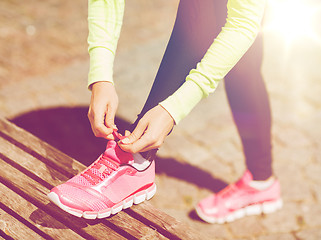 Image showing runner woman lacing trainers shoes