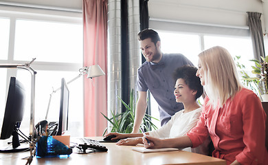 Image showing happy creative team with computer in office