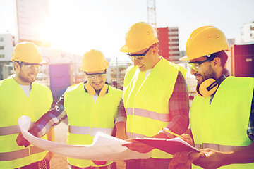 Image showing group of builders with tablet pc and blueprint