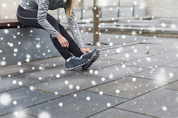 Image showing close up of sporty woman tying shoes outdoors