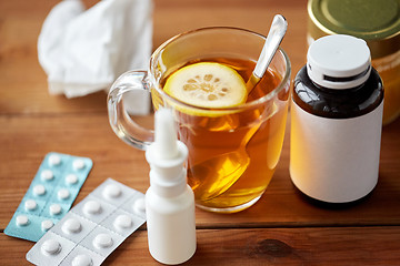 Image showing cup of tea, drugs, honey and paper tissue on wood