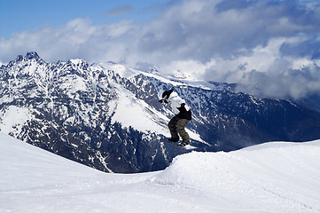 Image showing Snowboarder jumping in snow park at ski resort on winter day