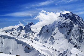 Image showing Winter mountains with snow cornice and blue sky with clouds in n