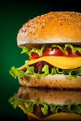 Image showing Tasty and appetizing hamburger on a darkly green