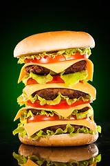 Image showing Tasty and appetizing hamburger on a darkly green