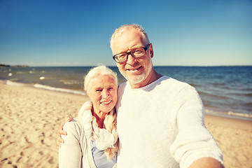 Image showing seniors taking picture with selfie stick on beach