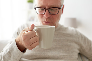 Image showing happy senior man drinking tea or coffee at home