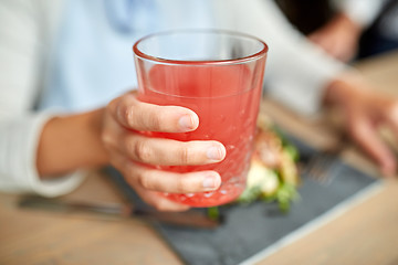 Image showing hand with glass of juice at restaurant