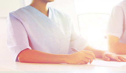 Image showing close up of doctor taking notes at hospital