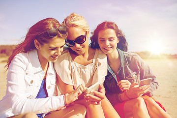 Image showing group of happy women with smartphones on beach