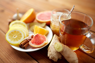 Image showing ginger tea with honey, citrus and cinnamon on wood