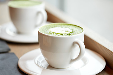 Image showing white cup of matcha green tea latte on table