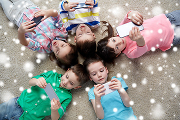 Image showing children with smartphones lying on floor