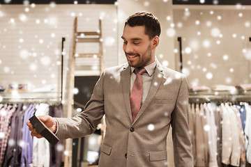 Image showing happy man holding little box in clothing store