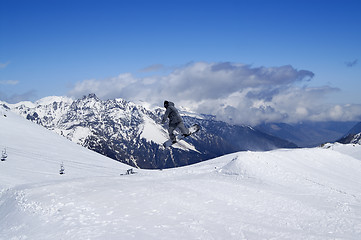 Image showing Snowboarder jumping in terrain park at snow mountain on sun wint